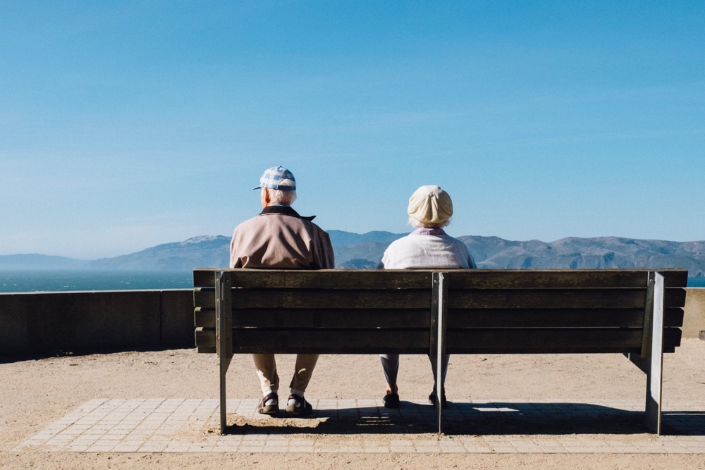 Rentnerpaar auf einer Banks sitzend, die Aussicht geniessen