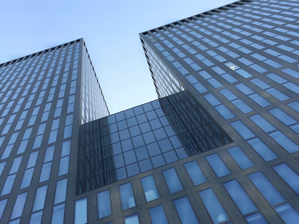 Symbolbild: Gebäude mit Glasfassade in Richtung Himmel aufgenommen